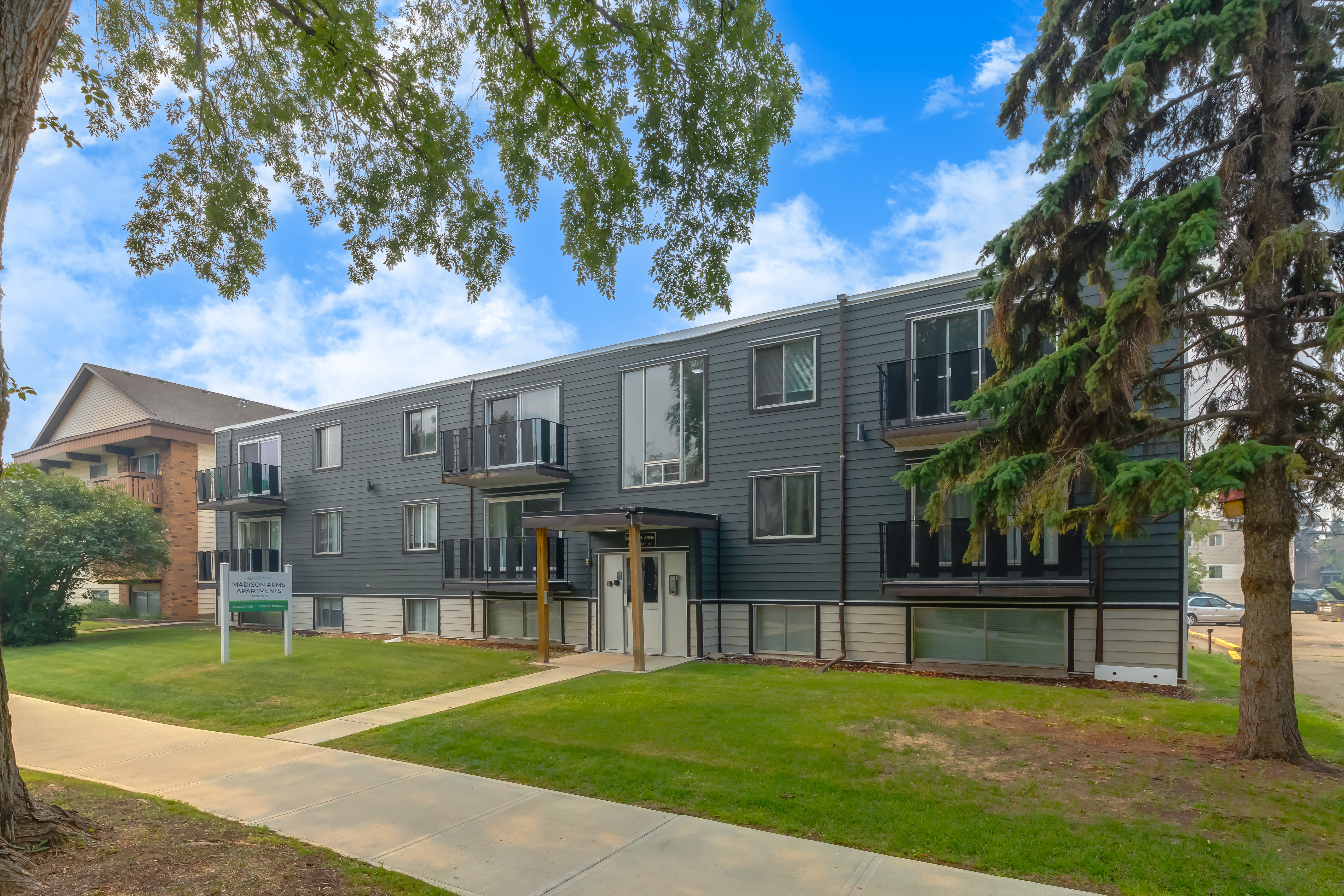 Image of the Madison Arms building surrounded by trees.