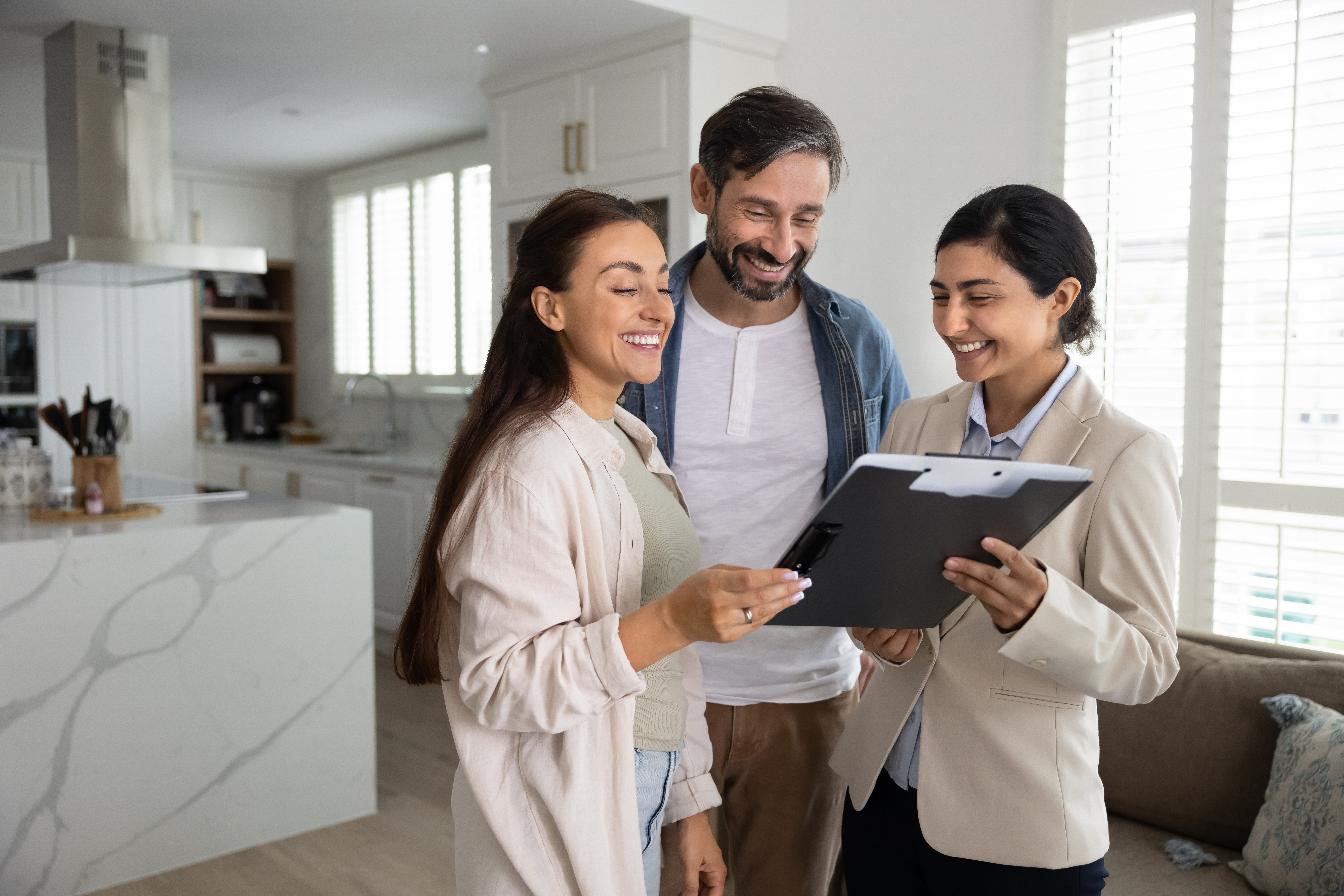 Couple reviewing real estate documents with an agent.