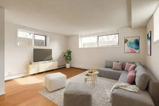 Image of a couch and TV in a basement suite.