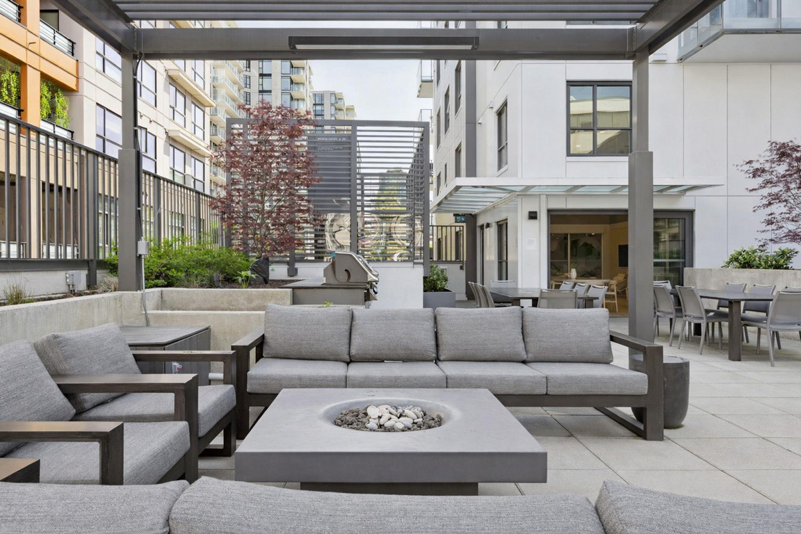 Victor_OutdoorLounge-2 Soft seating with couches, lounge chairs, and firepit beside outdoor dining space in residential outdoor amenity area