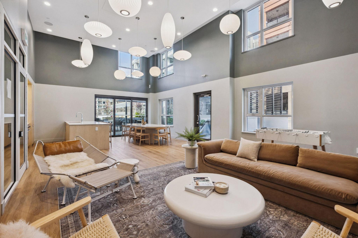 Victor_AmenityLounge-1 Social lounge with very high ceiling, modern lighting, kitchen, foosball table, and comfortable lounge area