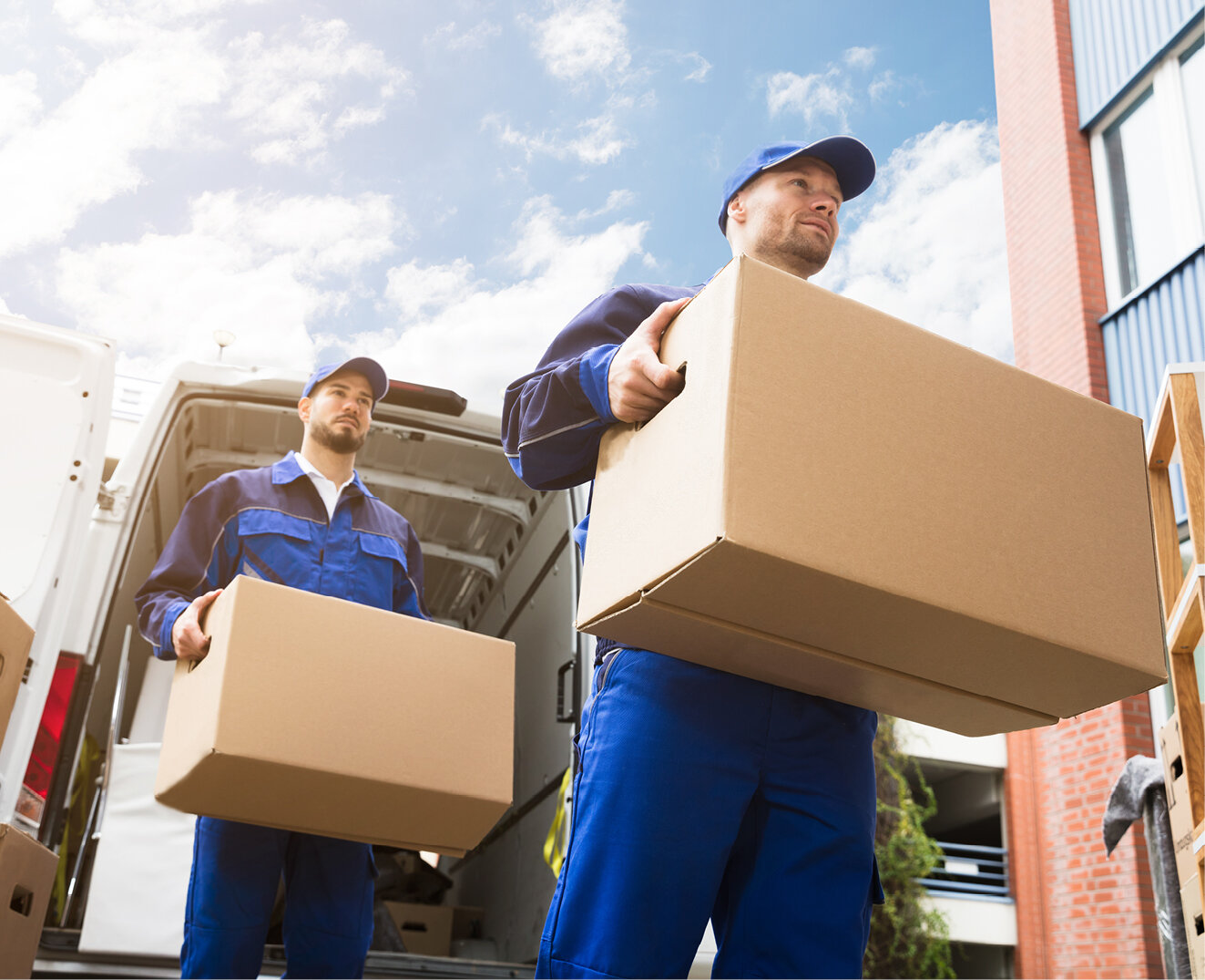 Two movers unloading boxes from a moving truck