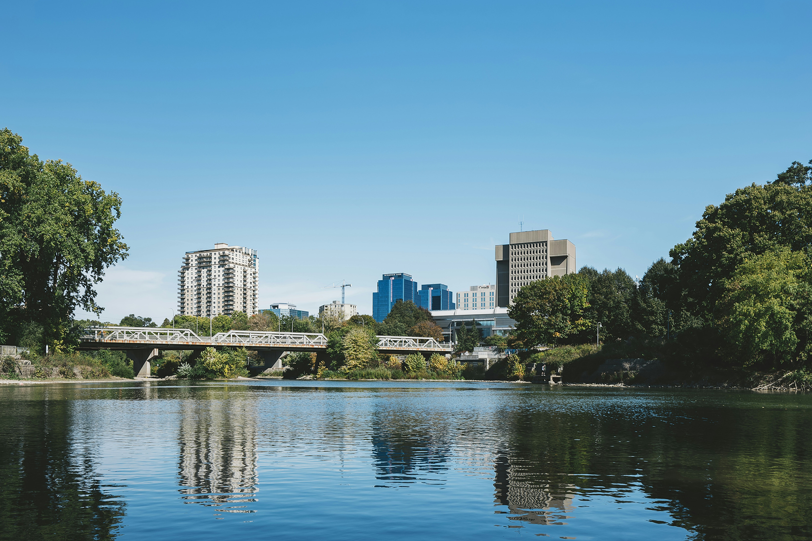 A bridge over of water with buildings in the background