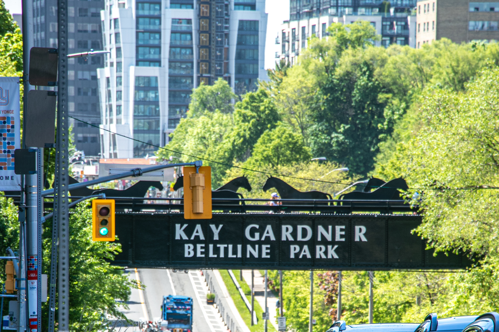 Image of the Kay Gardner Beltline Park bridge over a streetscape on a sunny day.