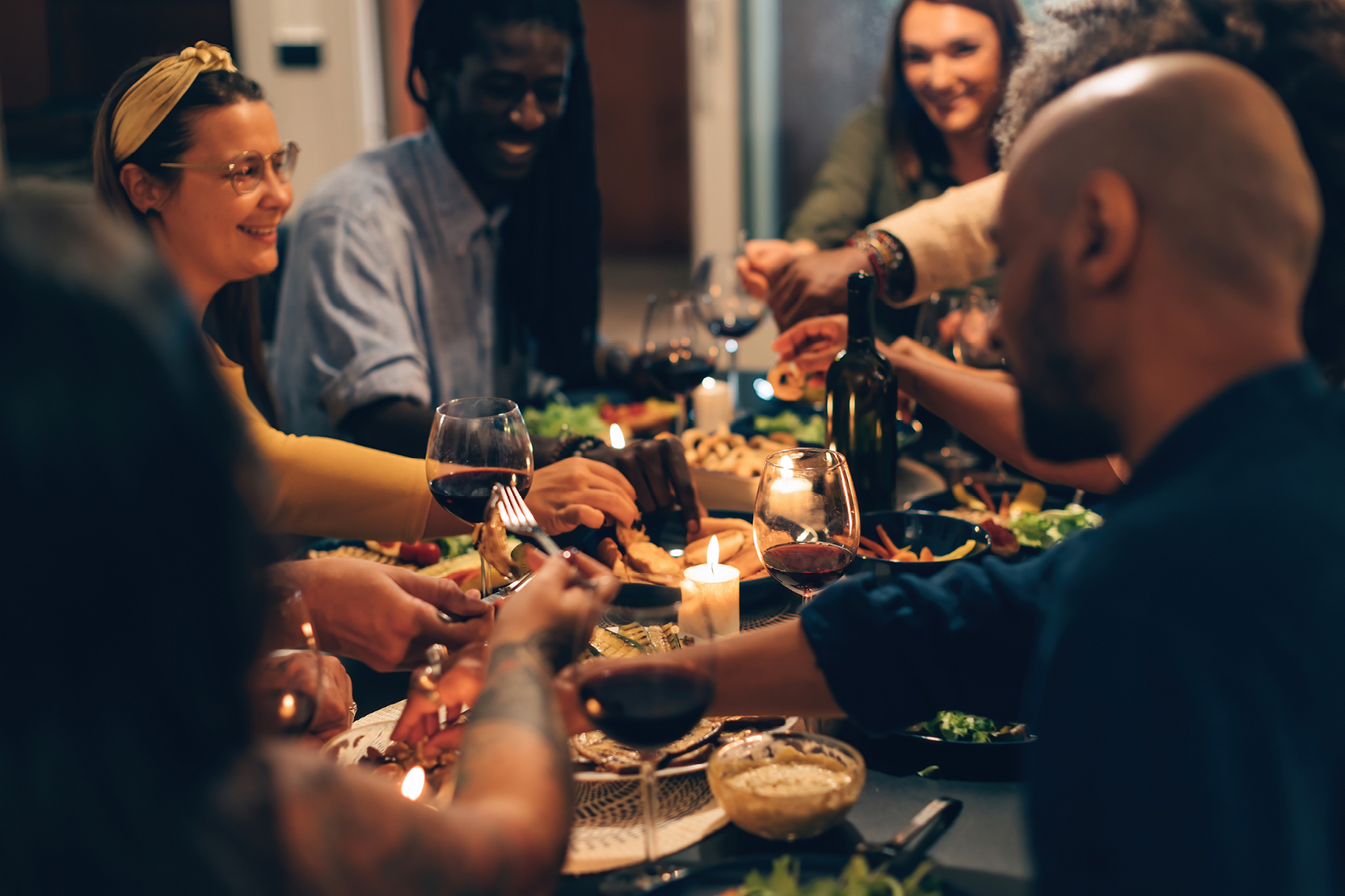 A group of friends gather around a table at a restaurant for dinner.