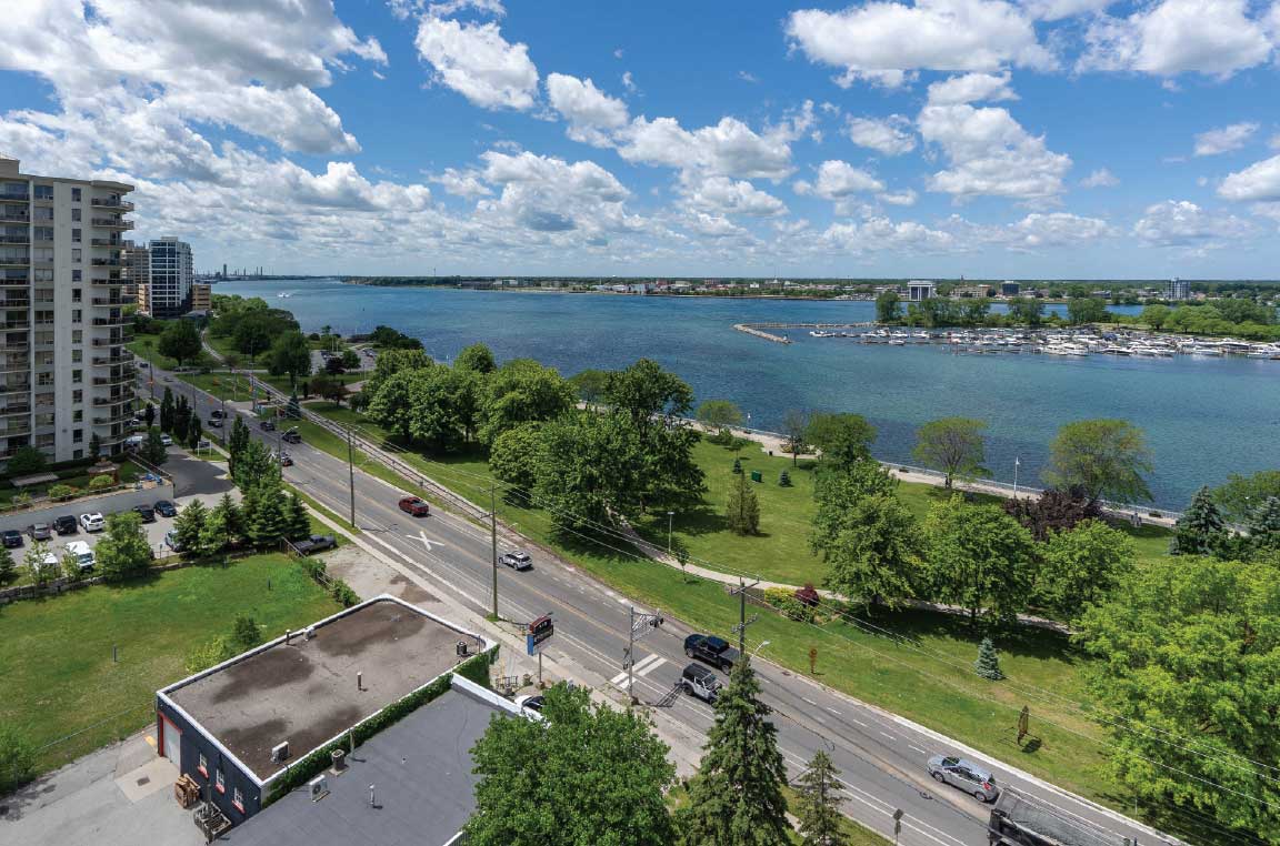 Balcony view overlooking the waterfront and lush green walking paths.